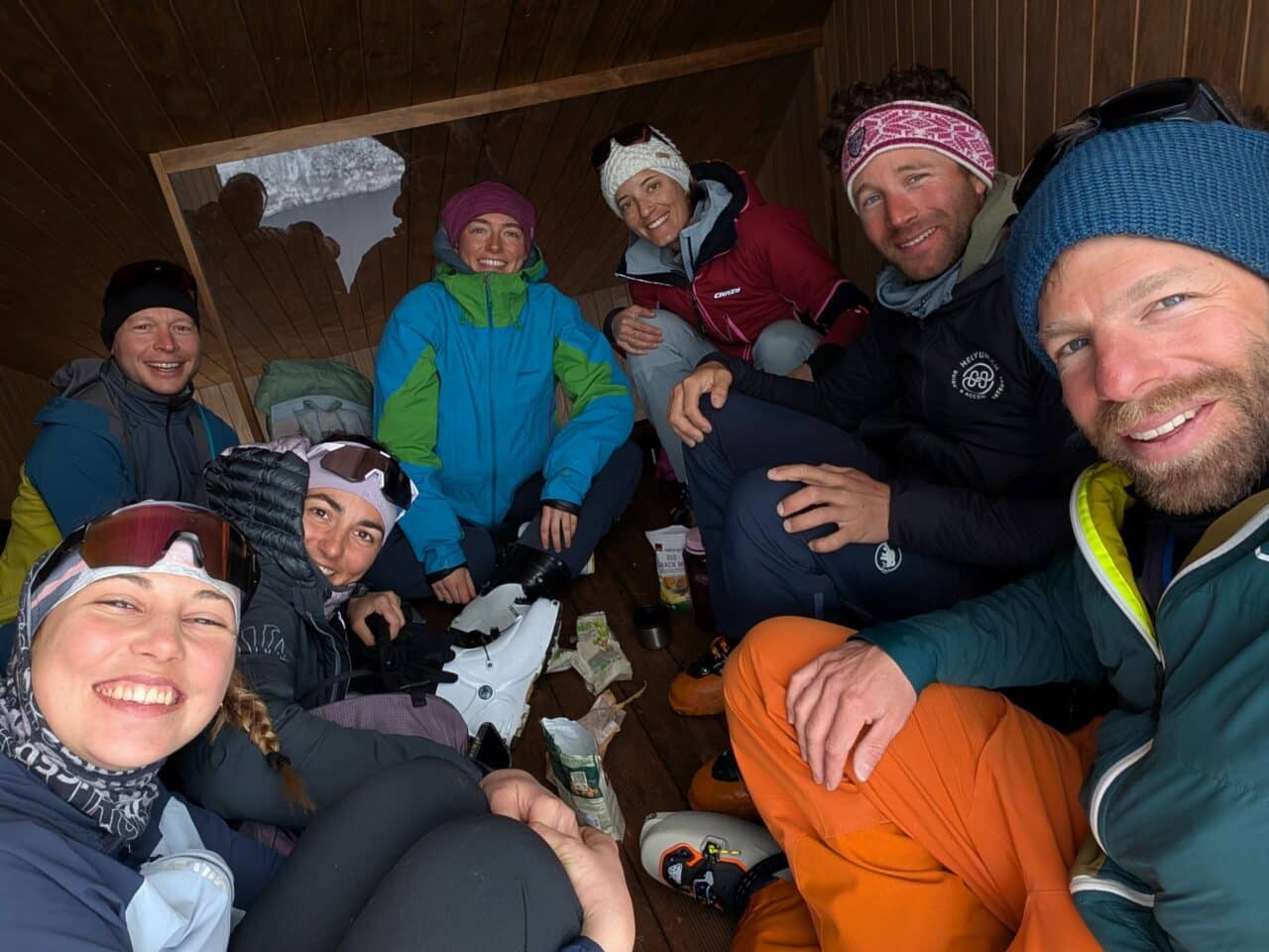 Groupe de skieurs en refuge norvégien se reposant à l’abri du vent lors d’un séjour ski dans le Finnmark