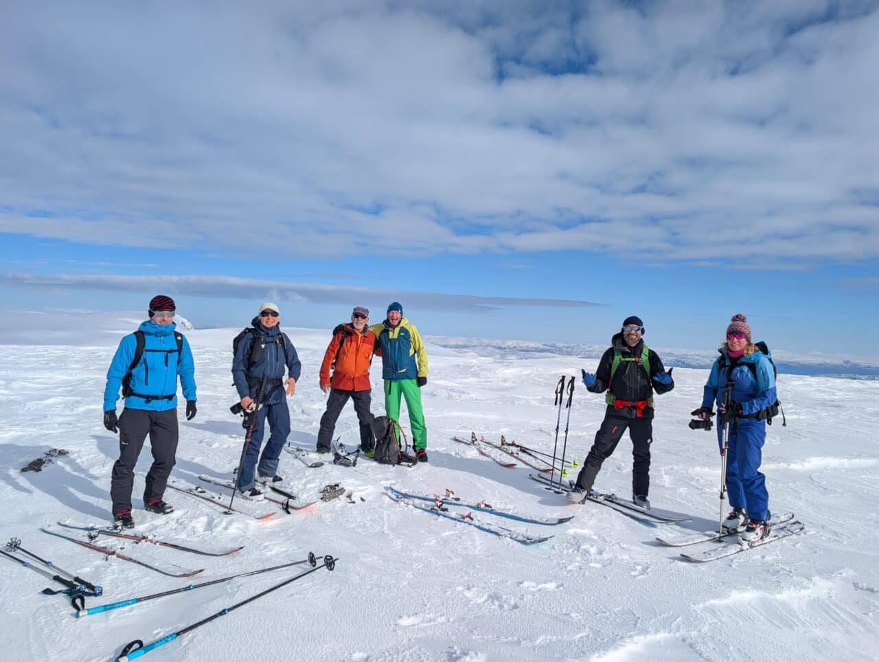 Groupe de skieurs au sommet dans le Finnmark en Norvège avec vue panoramique lors d’un séjour ski de randonnée
