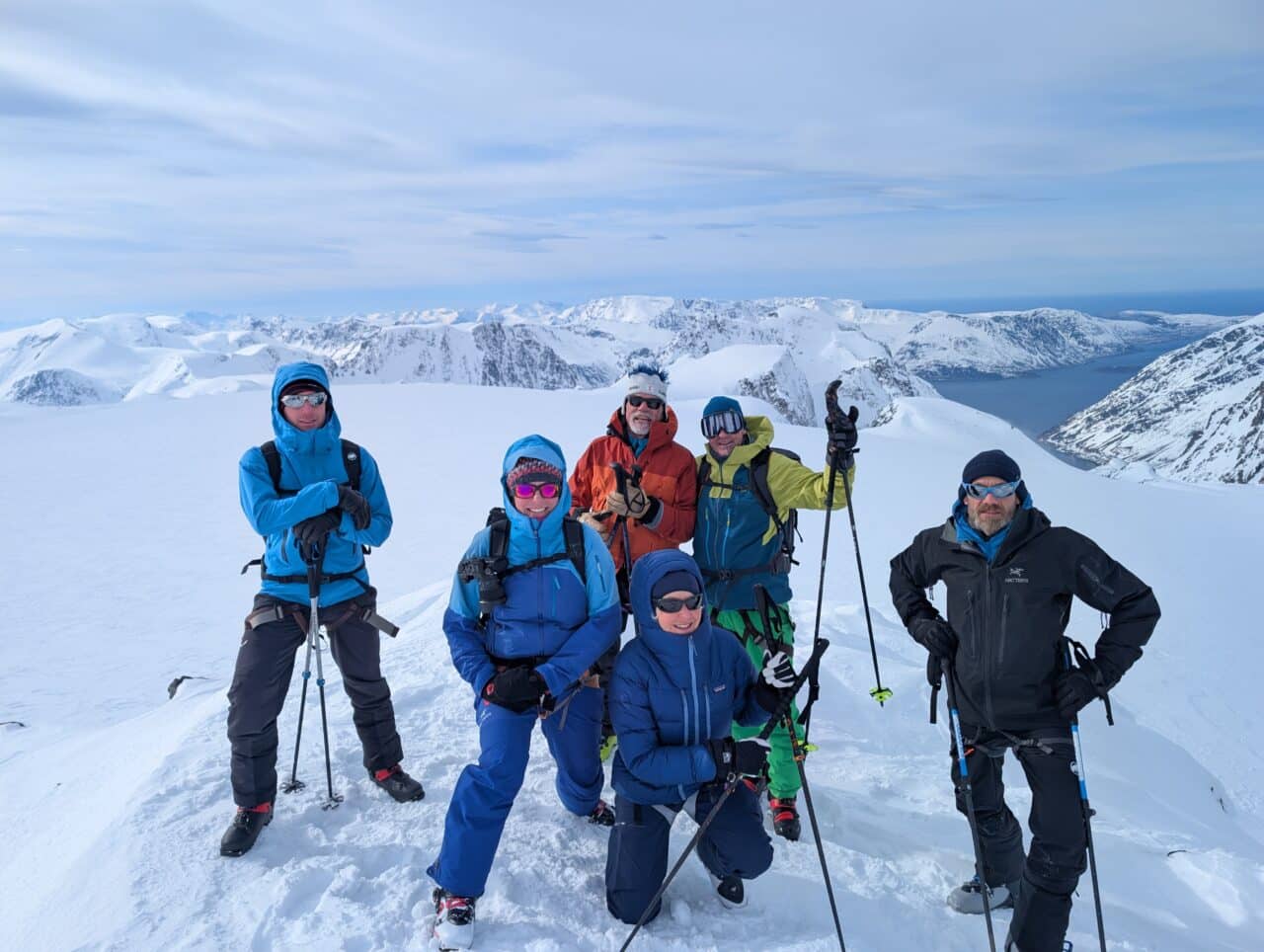 Groupe de skieurs au sommet dans le Finnmark en Norvège avec vue sur glacier et fjords en ski de randonnée