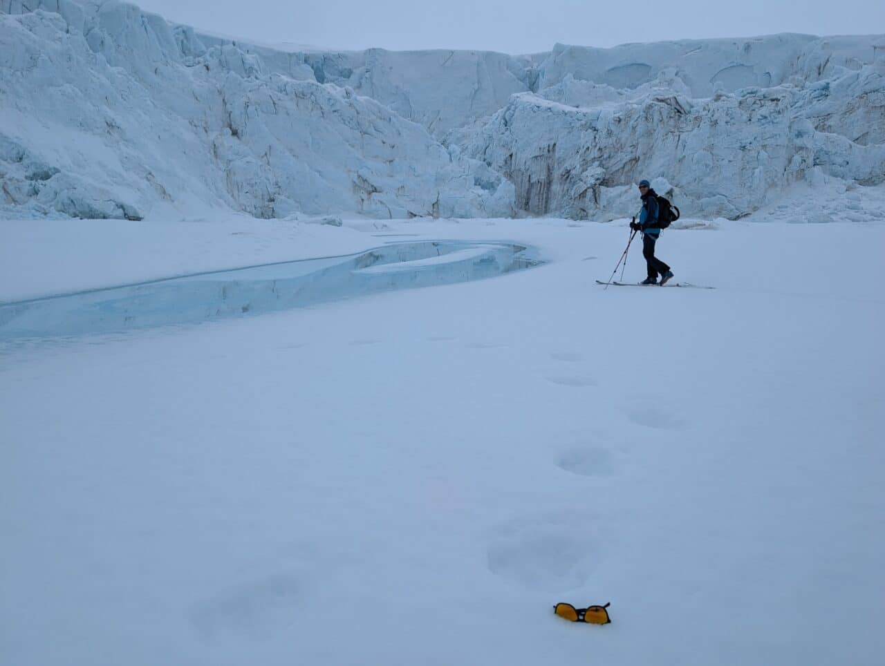 Skieur évoluant au pied d'un glacier dans une crique gelée du Svalbard
