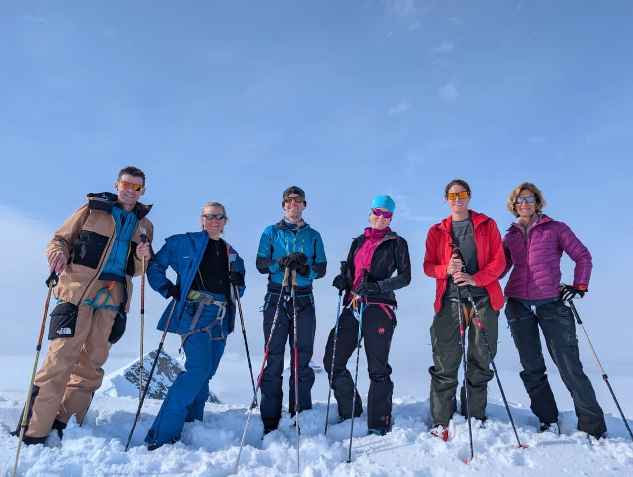 Groupe de skieurs de randonnée au sommet d'une montagne du Svalbard au-dessus des nuages
