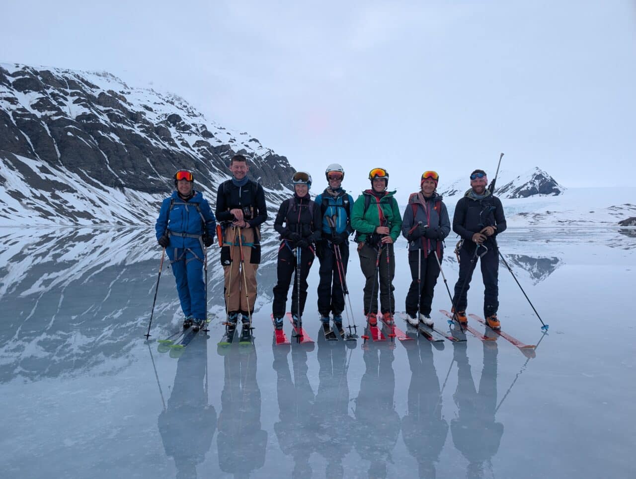Groupe de skieurs sur une banquise miroir devant un glacier du Svalbard