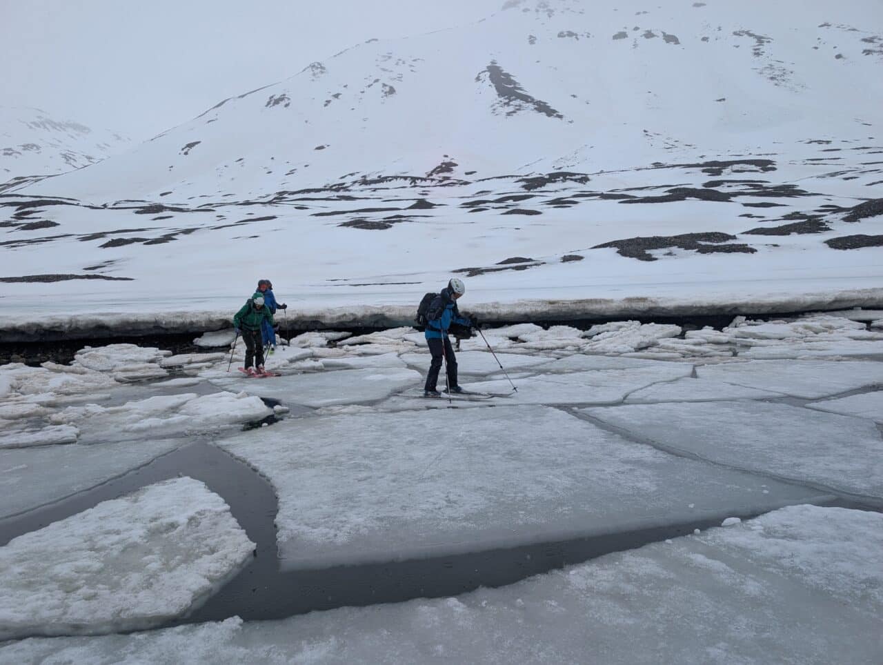 Skieurs traversant des plaques de glace flottantes pour rejoindre la banquise au Svalbard