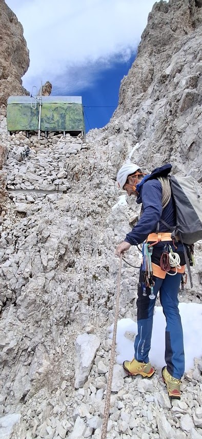 Bivouac de montagne installé près du sommet du Sassolungo dans les Dolomites, avec vue panoramique sur les parois rocheuses et les vallées environnantes.