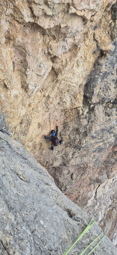 Grimpeur évoluant dans la voie Vinatzer sur la face sud de la Marmolada, au cœur des impressionnantes parois calcaires des Dolomites.