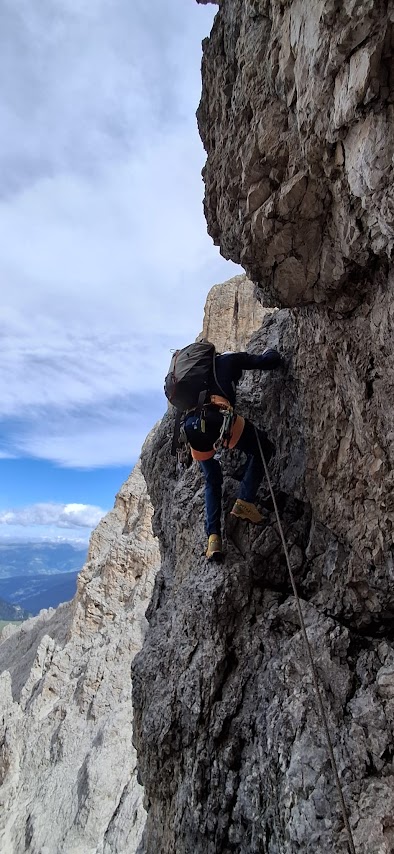 Alpiniste progressant sur les rochers de la voie normale du Sassolungo