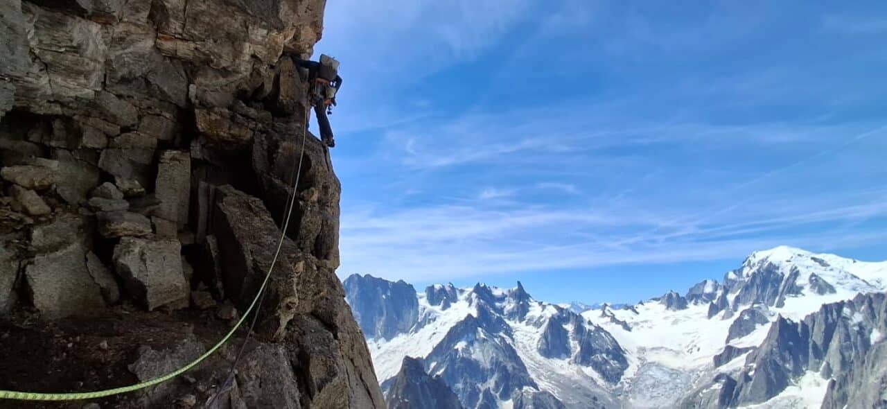 Grimpeur dans la traversée avant la longueur finale de la voie Contamine aux Drus, en pleine ascension alpine