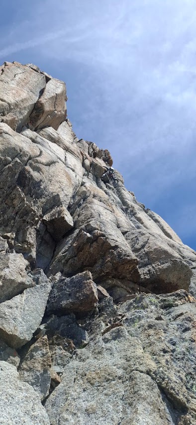 Grimpeur dans la dernière longueur difficile de la voie Contamine aux Drus, en pleine ascension alpine