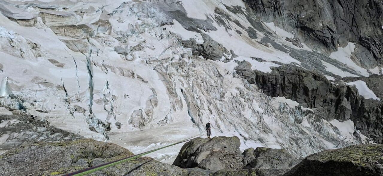 Grimpeur dans les rappels de la face sud du Grand Dru, en descente alpine technique